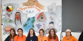 Les jeunes artistes de l'école Fréchette à l'Anse-Saint-Jean posent en dessous de leur oeuvre.