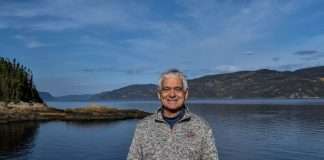 Jean bergeron pose fièrement devant le fjord du Saguenay au quai de petit-Saguenay