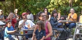 Une maman et sa fille sur les genoux au 5 à 7 organisé au Camp de Base de l'Anse-Saint-Jean