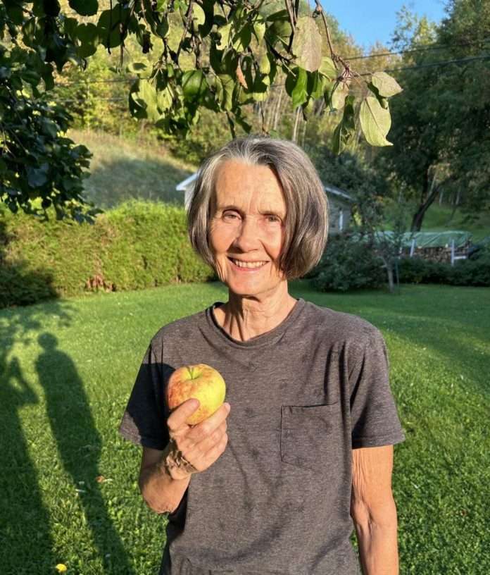 Une femme tient une pomme dans ses mains.