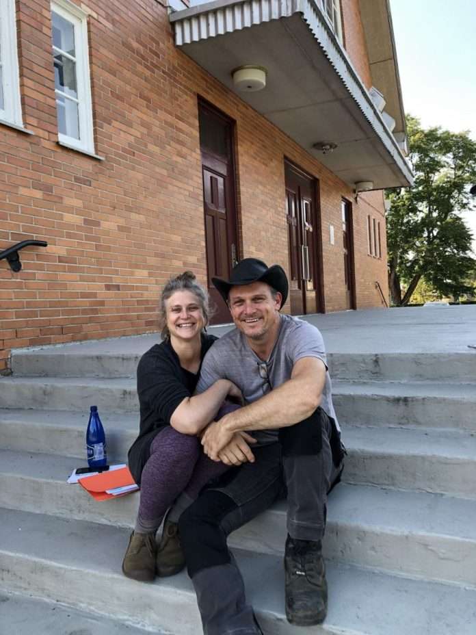 Dex personnes assises sur les marches de l'église de Petit-Saguenay