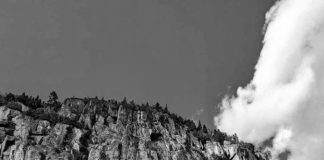 Une femme au pied des falaises du fjord du Saguenay.