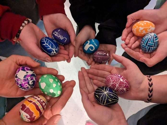 Des mains tiennent des oeufs décorés selon la tradition ukrainienne