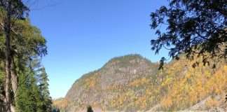 des jeunes assis au bord du Lac Emmuraillé, à L'Anse-Saint-Jean