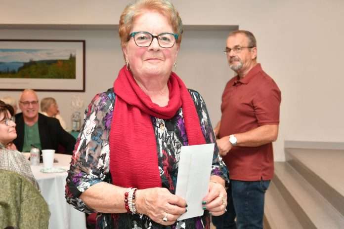 Une femme tient fièrement sa lettre de remerciement