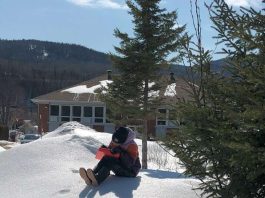 un jeune écrit assis sur la neige