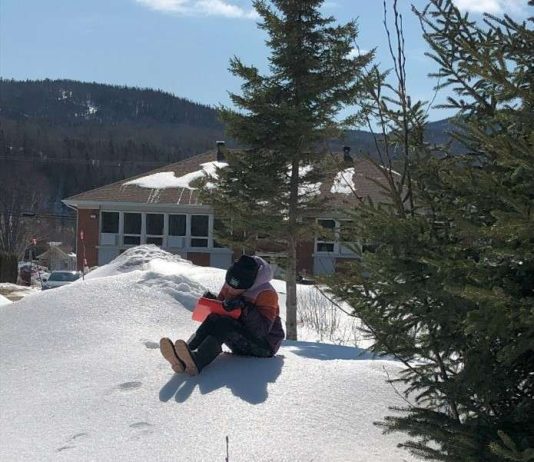 un jeune écrit assis sur la neige