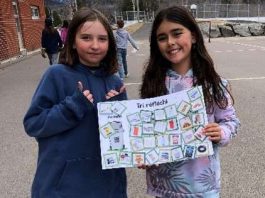Deux jeunes filles nous montrent une pancarte sur le tri sélectif