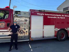 Un pompier pose fièrement devant le camion de l RISIF à Sant-Félix-d'Otis