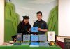 Deu xpersonne stiennent un stand dans un salon du livre