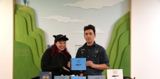 Deu xpersonne stiennent un stand dans un salon du livre