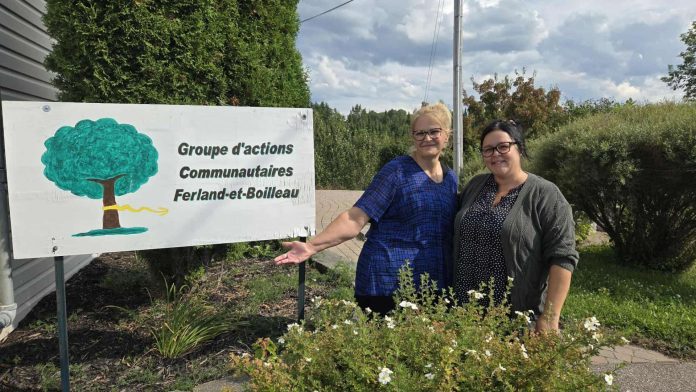Deux femmes prennent la pause devant la pancarte de leur organisme