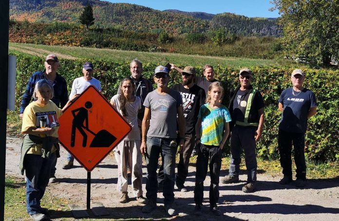 Groupe de personnes sur le bord d'une rivière à L'Anse-Saint-Jean