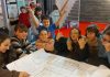 Des jeunes autour d'une table dessinent leur projet de local