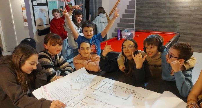 plan+gang Des jeunes autour d'une table dessinent leur projet de local
