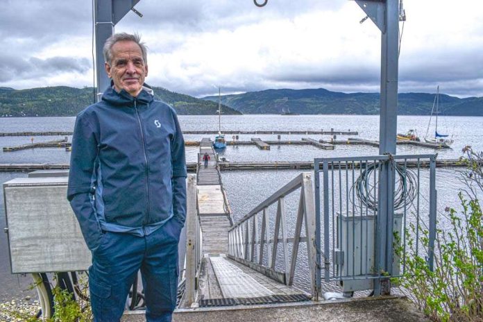 un homme pose les mains dans les poches devant la marina de L'Anse-Saint-Jean