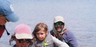 deux adultes et une enfant débarquent d'un canot